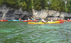 group kayaking along the shoreline