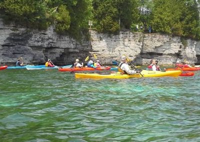 group kayaking along the shoreline