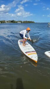 man crouching on paddle board