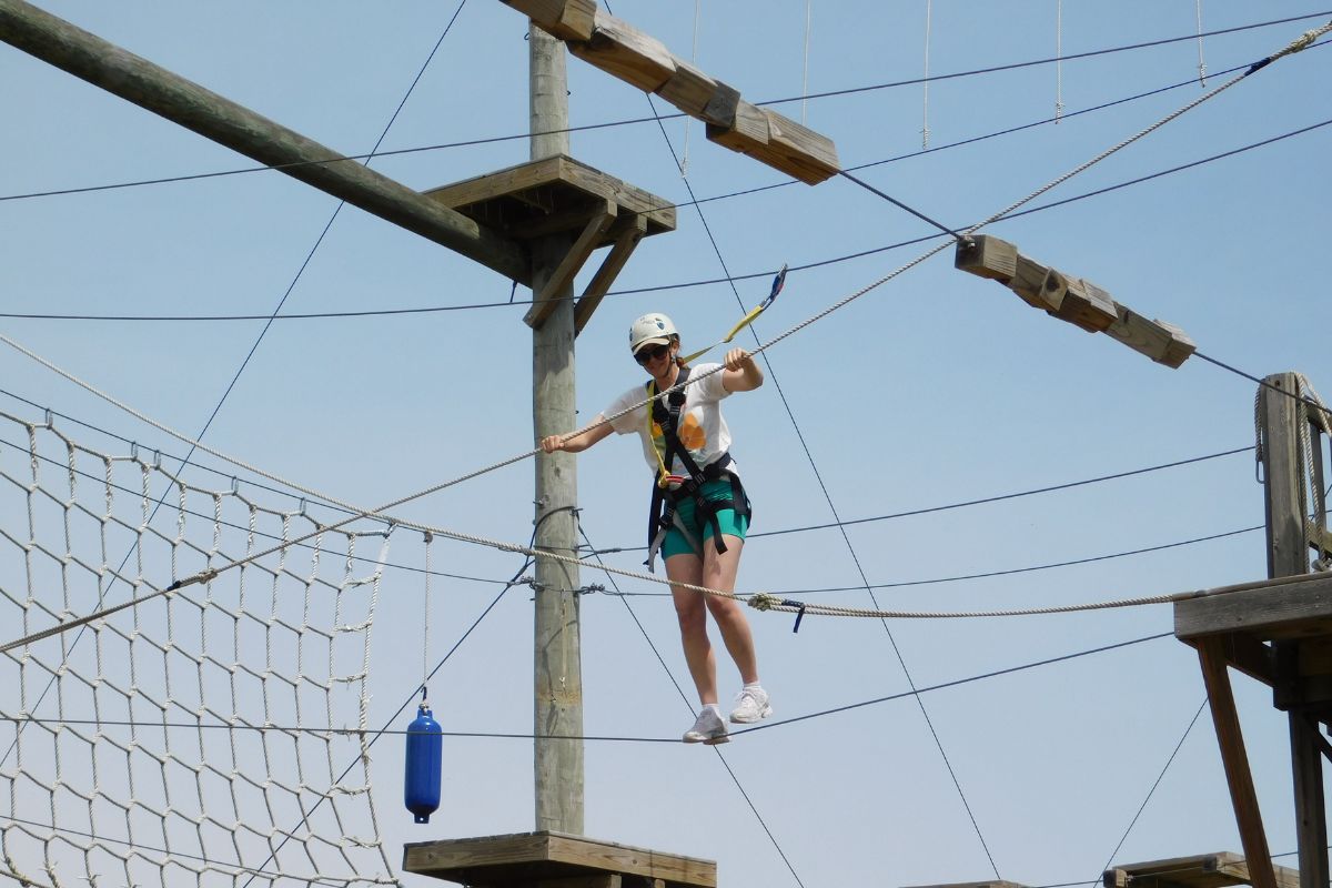 Woman crossing the adventure park at our Team Leadership Center